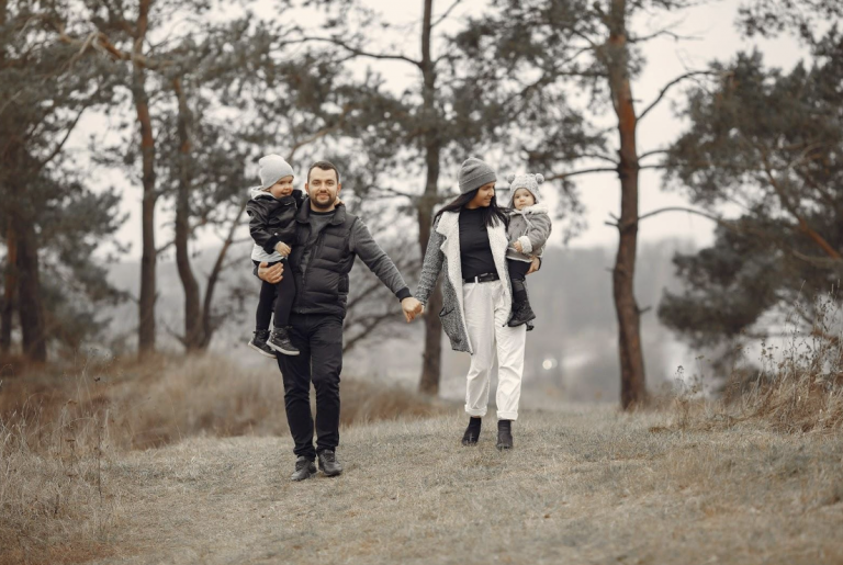 cute family in stylish clothes walking in a forest